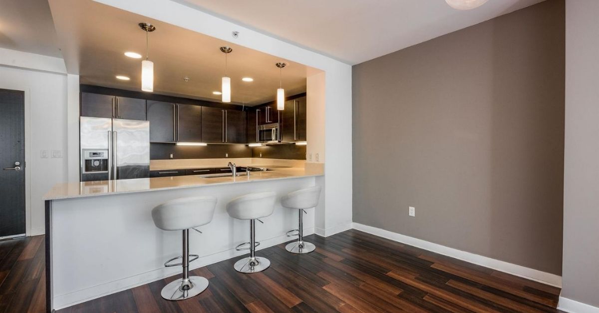 Kitchen in San Francisco condo with sub zero fridge and white bar stools