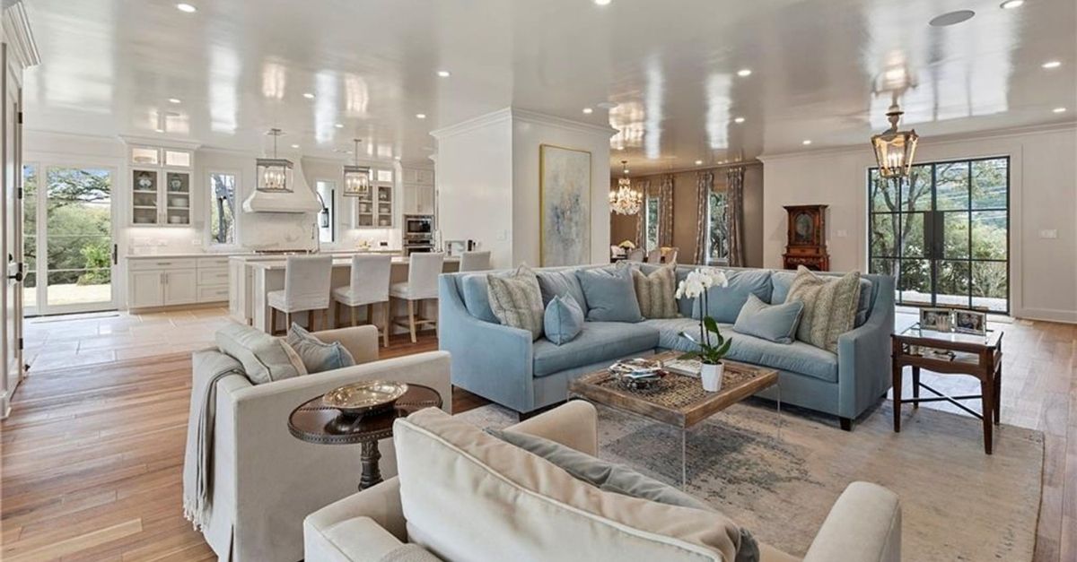 Open floor plan room with white marble kitchen in the background and living area in the front