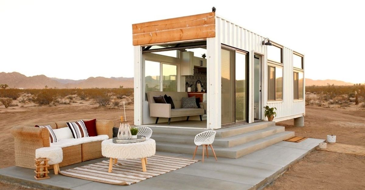 Shipping container tiny home with sun setting behind it