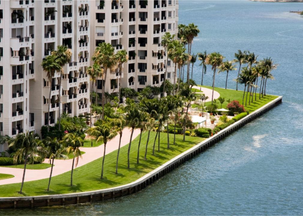 Condo building on waterfront with palm trees
